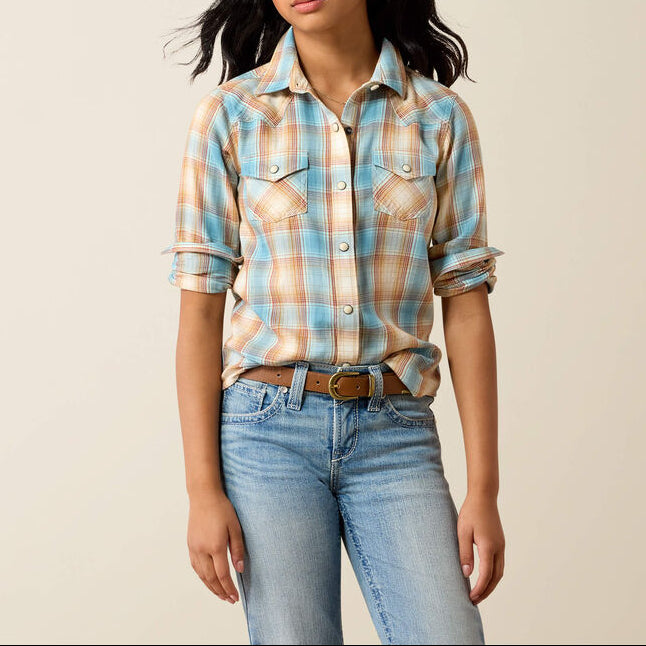 10079458 Ariat Girls Creekside Snap Shirt at boltranchstore.com A young woman modeling a light blue, peach, and white plaid western-style flannel shirt with rolled-up sleeves kids western shirt