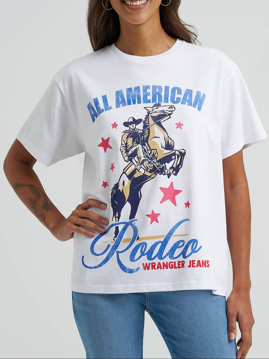 112375885 Wrangler Womens All American Rodeo Girlfriend Graphic Tee at boltranchstore.com free shipping womens rodeo shirt red white and blue shirt Woman wearing a white t-shirt with 'All American Rodeo in stock