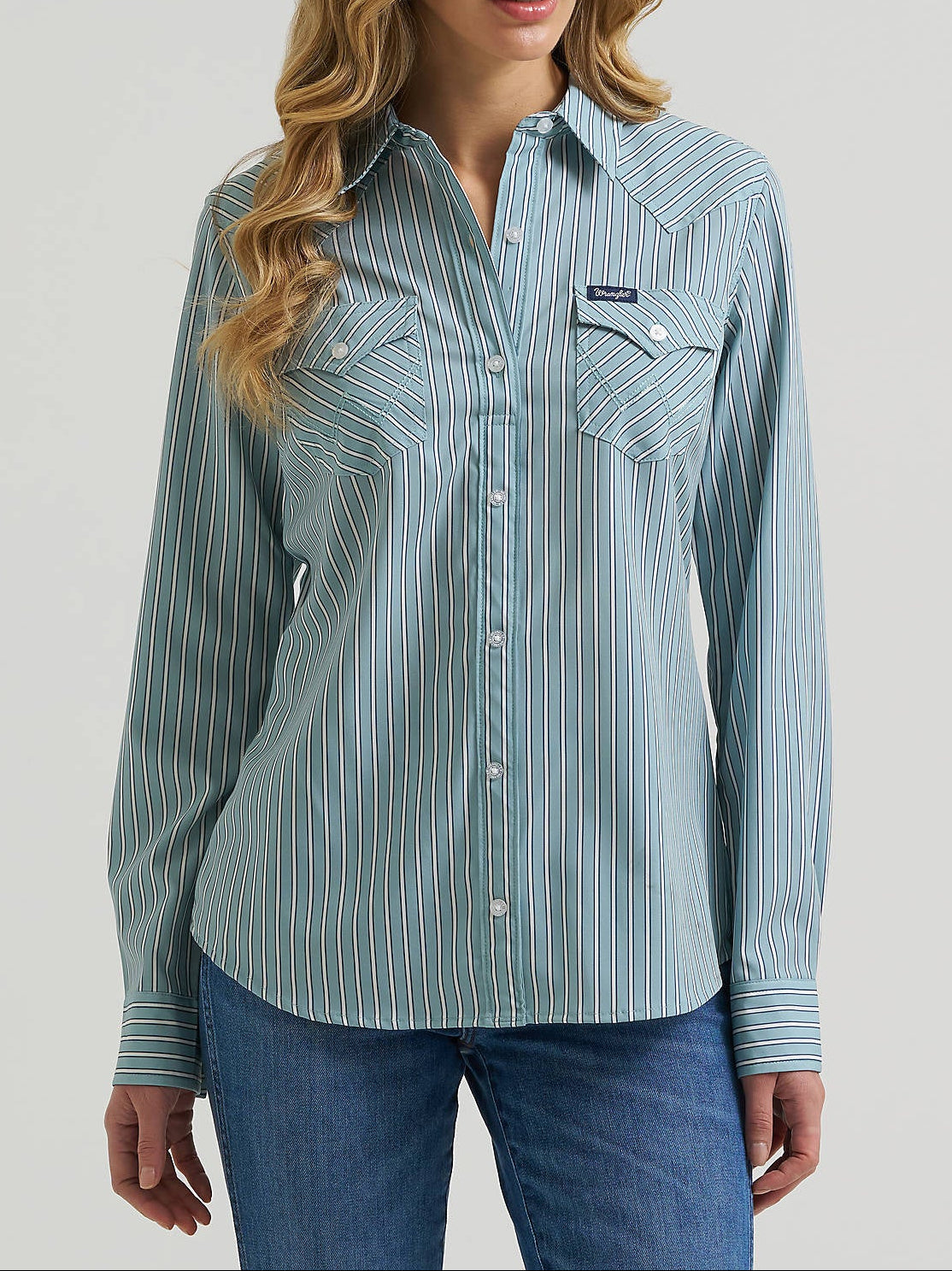 Wrangler Womens Performance Aria Shirt A long-sleeve western-style button-up shirt with thin vertical stripes in sage green and white, featuring two buttoned chest pockets
