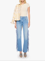 wearing light-wash blue jeans with long fringe detailing down the outer legs womens western jean nfr outfit jeans 11495-1219-Mother The Fringe Desperado Sneak at boltranchstore.com in stock free shipping 