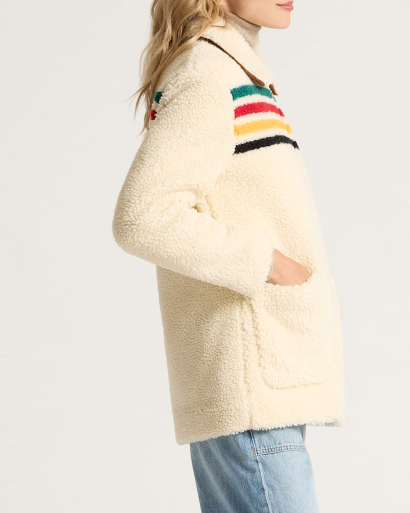 Woman wearing a cream-colored jacket with colorful stripes 