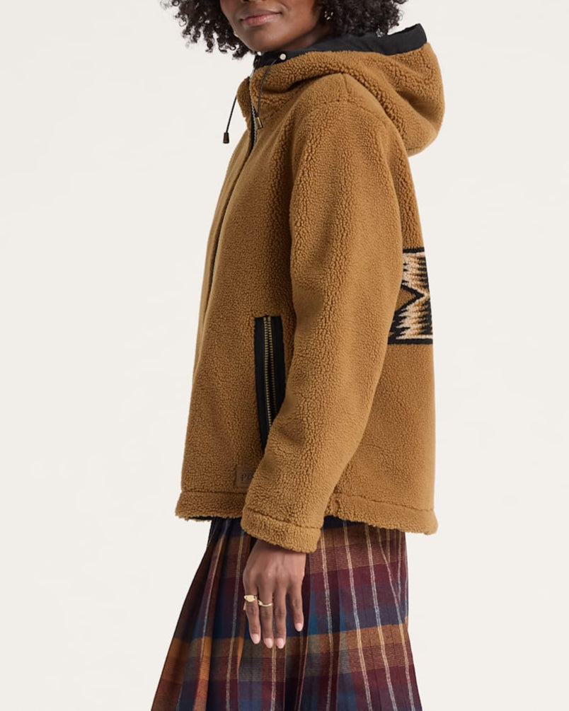 Woman wearing a brown fleece jacket with a patterned design on a white background