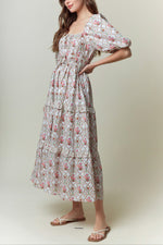 Woman wearing a floral dress against a plain background