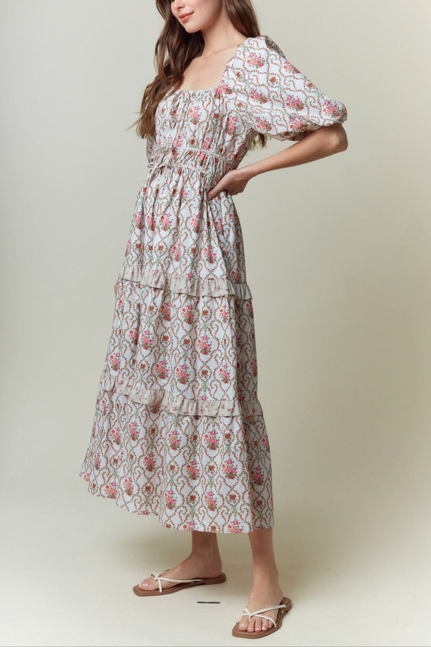Woman wearing a floral dress against a plain background
