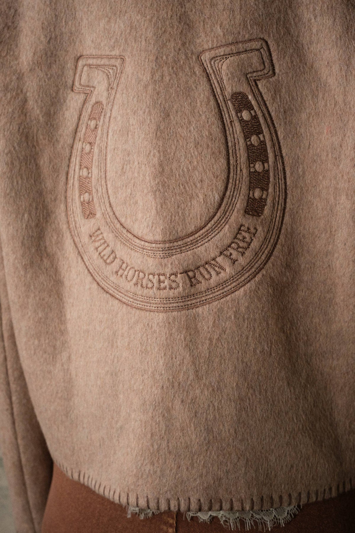 Blue B Western Two Tone Embroidered Jacket Mocha horseshoe motif reading Wild Horses Run Free above blanket stitched hem edges
