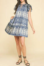 women's Naomi mini dress features a charming blue and cream print, complemented by delicate ruffled sleeves and a tiered design that adds playful movement and style Boltranchstore.com Free shipping