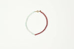 A delicate beaded necklace with alternating strands of pale mint green and deep red beads joined by a small gold clasp displayed on a clean white background shop at boltranchstore.com