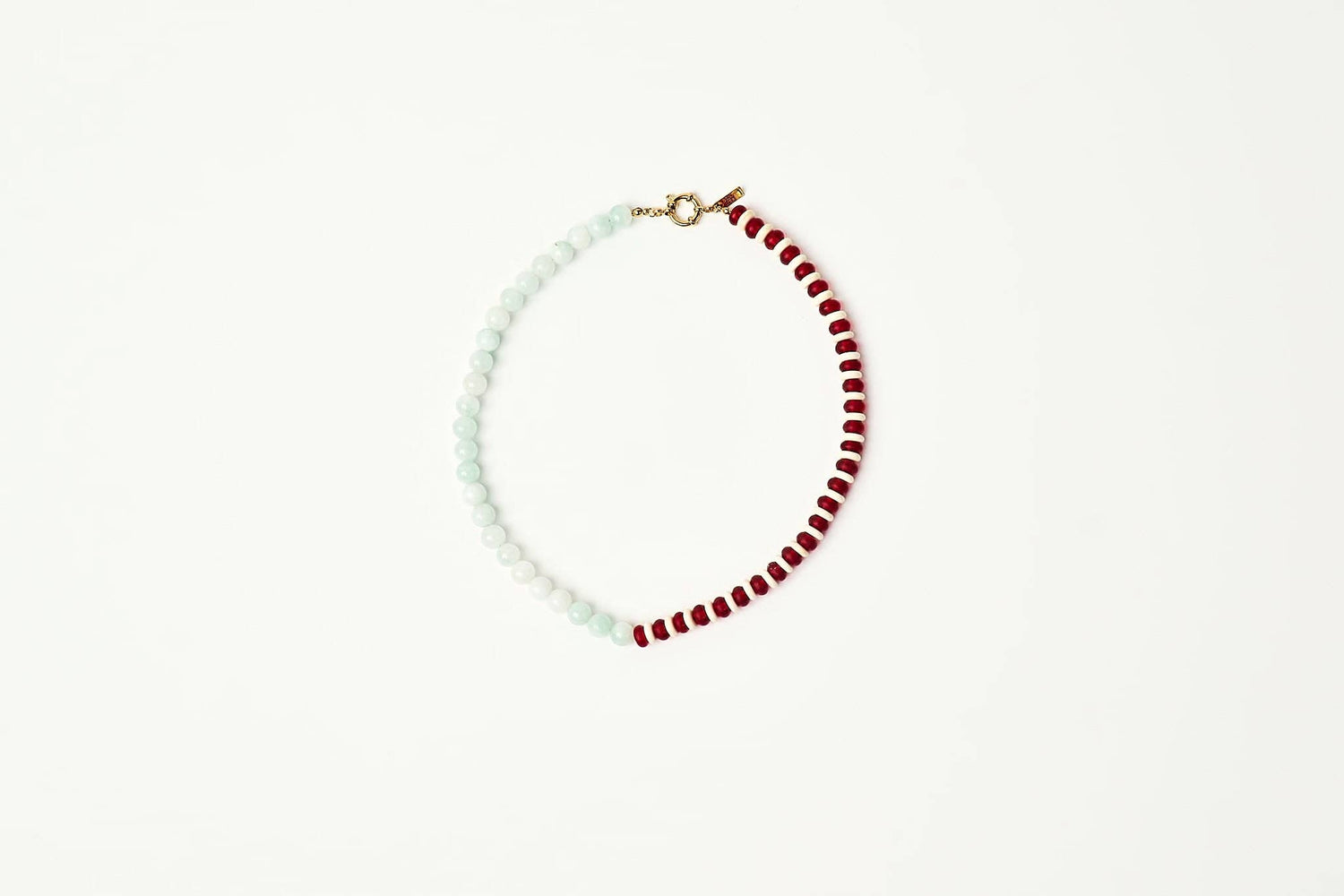 A delicate beaded necklace with alternating strands of pale mint green and deep red beads joined by a small gold clasp displayed on a clean white background shop at boltranchstore.com