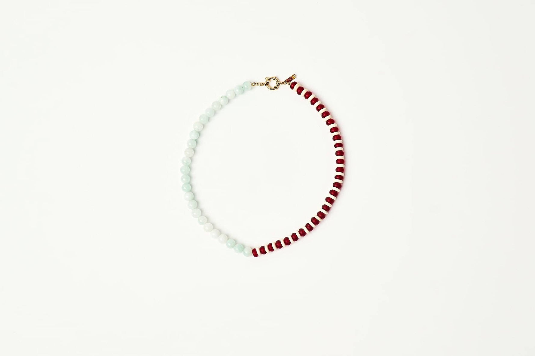 A delicate beaded necklace with alternating strands of pale mint green and deep red beads joined by a small gold clasp displayed on a clean white background shop at boltranchstore.com
