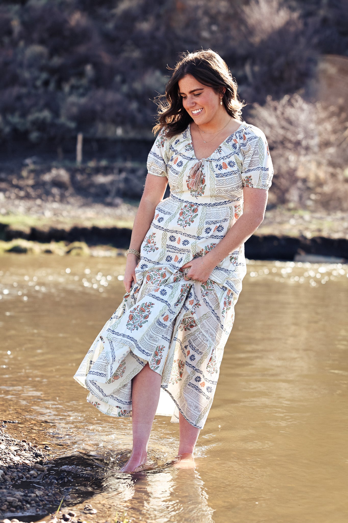 The Ayana dress features an adjustable gathered neckline, creating a sweet and soft silhouette. Outfitted in a&nbsp;soft floral patter of greens, blues and salmon hues, this dress features subtle puff sleeves for added charm balancing simplicity and grace.