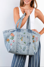 The Perfect Sized Blossom Tote Billy T denim bag zipper Boltranchstore.com free shipping Woman holding a denim tote bag with floral embroidery against a white background
