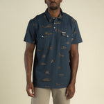 Cantina Pique Polo Short Sleeve Shirt At boltranchstore.com in stock free shipping A man wearing a dark blue short-sleeve button-up shirt with a brown animal print pattern.