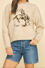 Carol Cowboy Crew Sweater with a bucking cowboy on the front in a knitted sweater available in ivory and oatmeal at boltranchstore.com