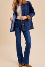 A dark blue denim jacket with brown corduroy collar and cuffs, button up fronts, two front pockets and a button back detail.
