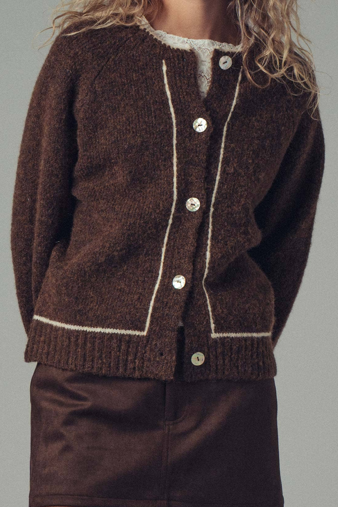 Brown knitted cardigan with white buttons on a plain background ballerina farms doen winter sweater fall sweater