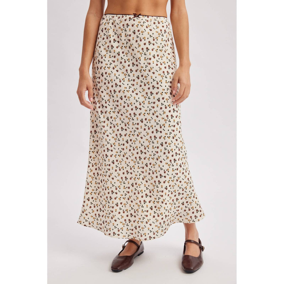 Ditsy Floral Midi Skirt at boltranchstore.com in stock free shipping A model wearing a cream-colored maxi skirt with a brown and black floral  print pattern