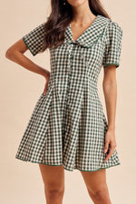 A forest white gingham midi dress, full button up and a tie in the front with short sleeves