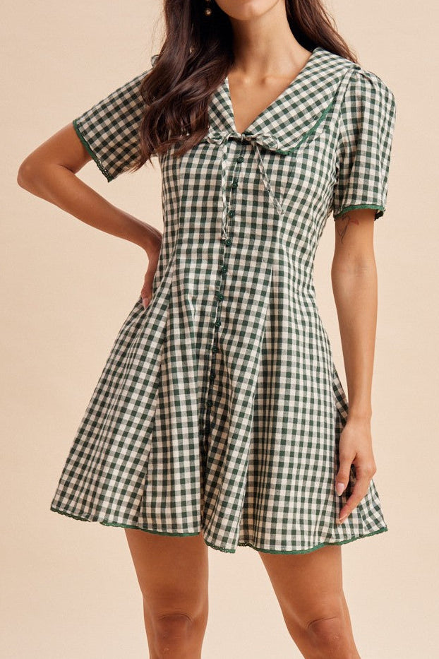 A forest white gingham midi dress, full button up and a tie in the front with short sleeves