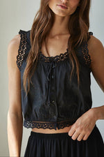 The Grace sleeveless black top features a round detailed neckline, button-down front with tie detail, and delicate lace trim free shipping at Boltranchstore.com
