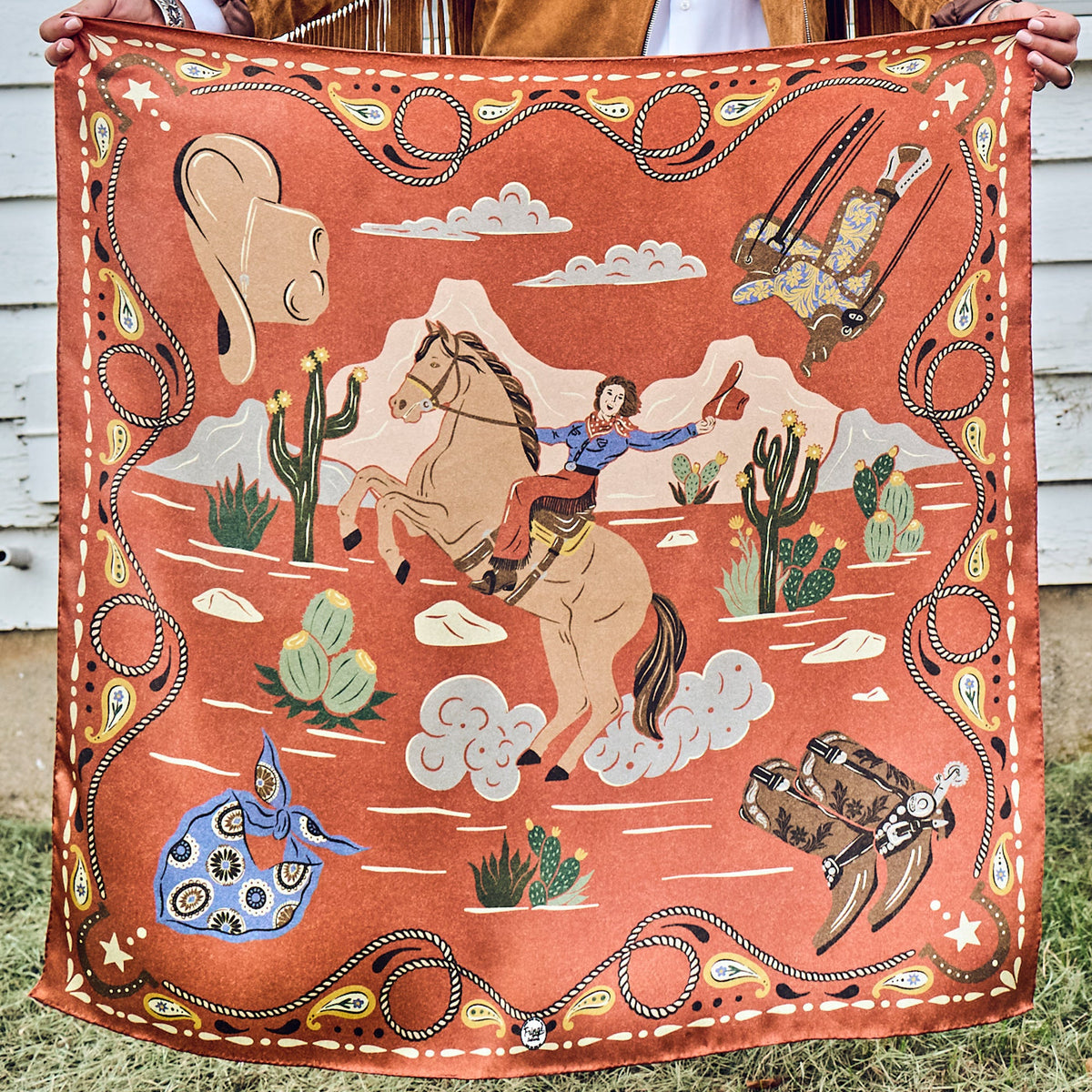 Fringe Happy Trails Silk Scarf Cayenne retro cowgirl on horseback with western gear in each corner on cayenne womens western boutique Utah SKU SCRFHPTLCYRDSH26037