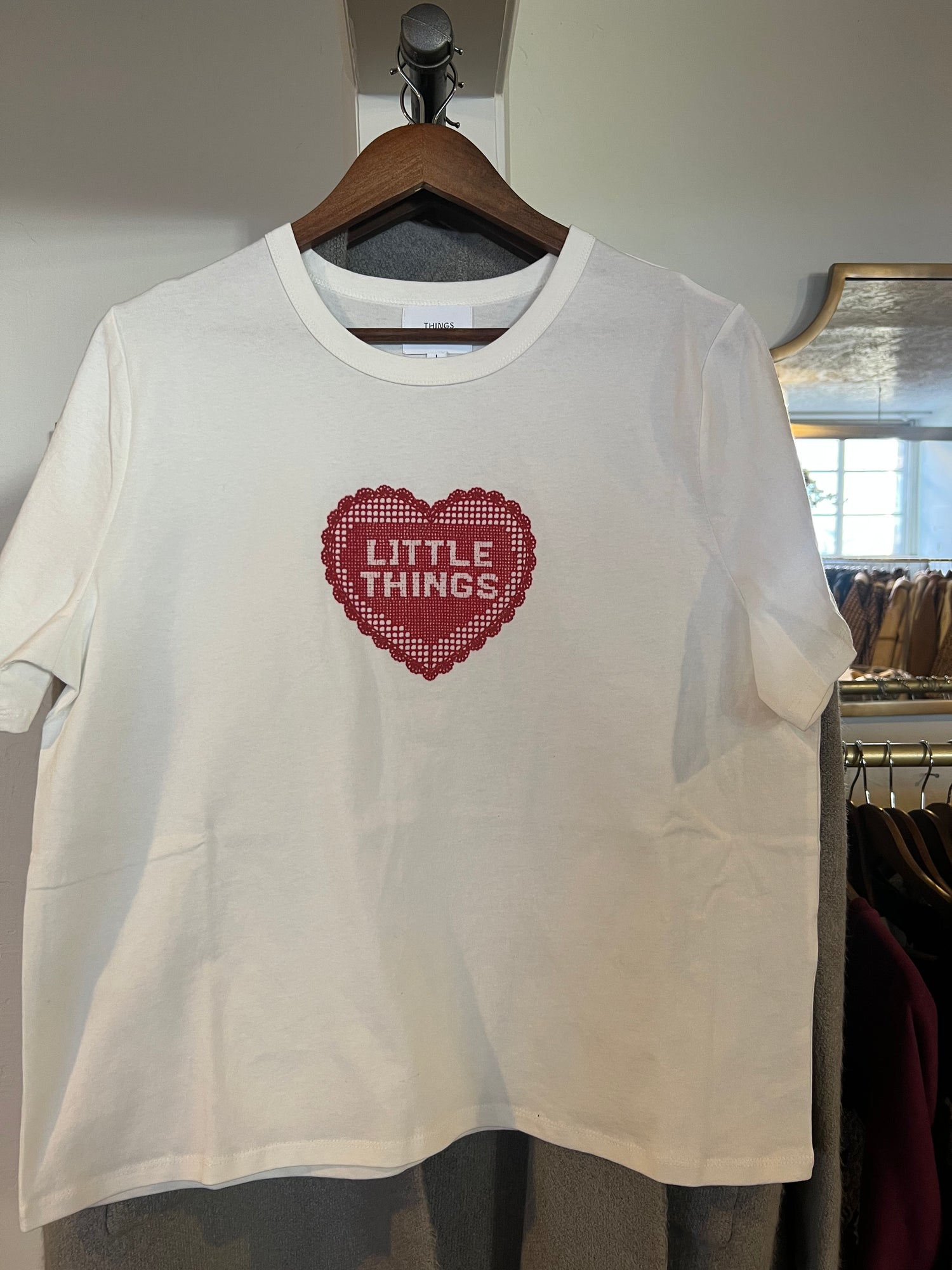 White t-shirt with red heart design and 'LITTLE THINGS' text on a hanger. boltranchstore.com Bolt Ranch crochet design 