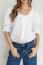 Mallory Blouse at boltranchstore.com  in stock free shipping A woman modeling a white short-sleeve blouse with puffed sleeves, ruffled trim, and a button-front bodice womens white shirt 
