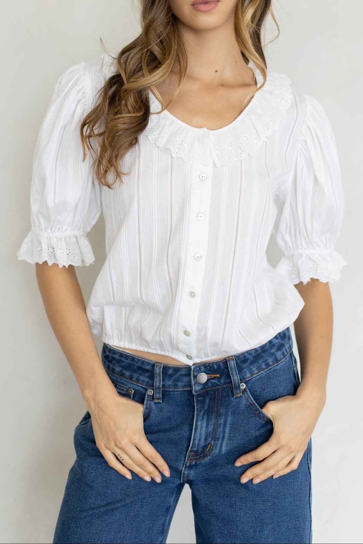 Mallory Blouse at boltranchstore.com  in stock free shipping A woman modeling a white short-sleeve blouse with puffed sleeves, ruffled trim, and a button-front bodice womens white shirt 