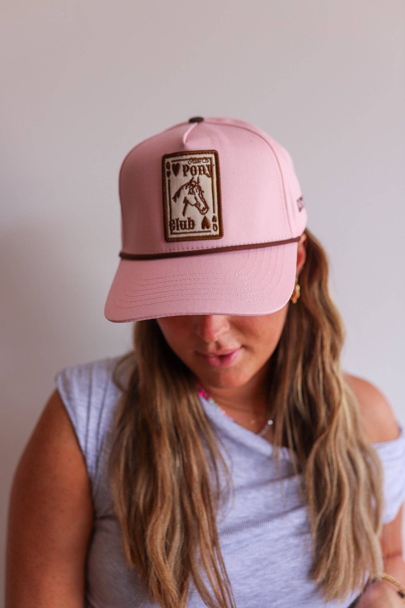 A pink pony hat with embroidered patch brown visor rope in a snap back at boltranchstore.com