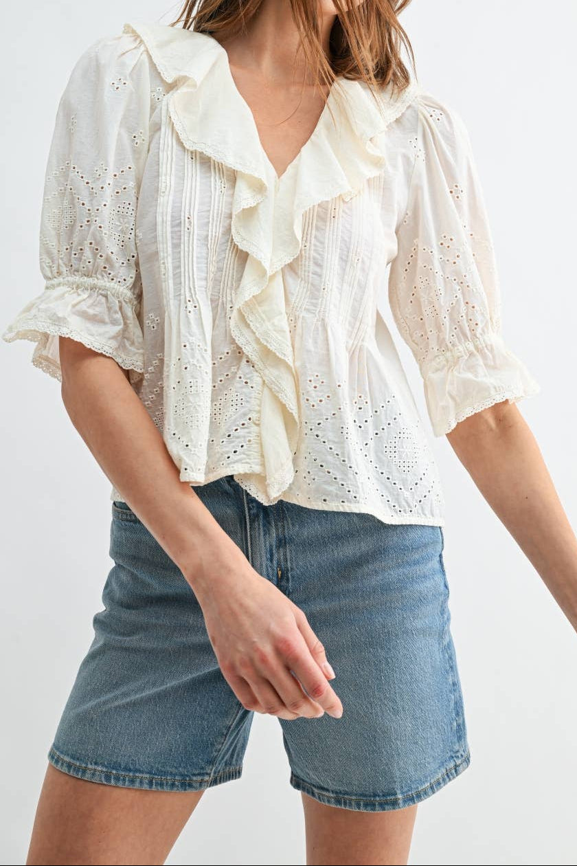 Raelynn Eyelet Ruffle Pintuck Puff Sleeve a with a ruffle front eyelet detail on the top and sleeves a flutter puff half sleeve wtih a v neck and ruffle collar detail at boltranchstore.com