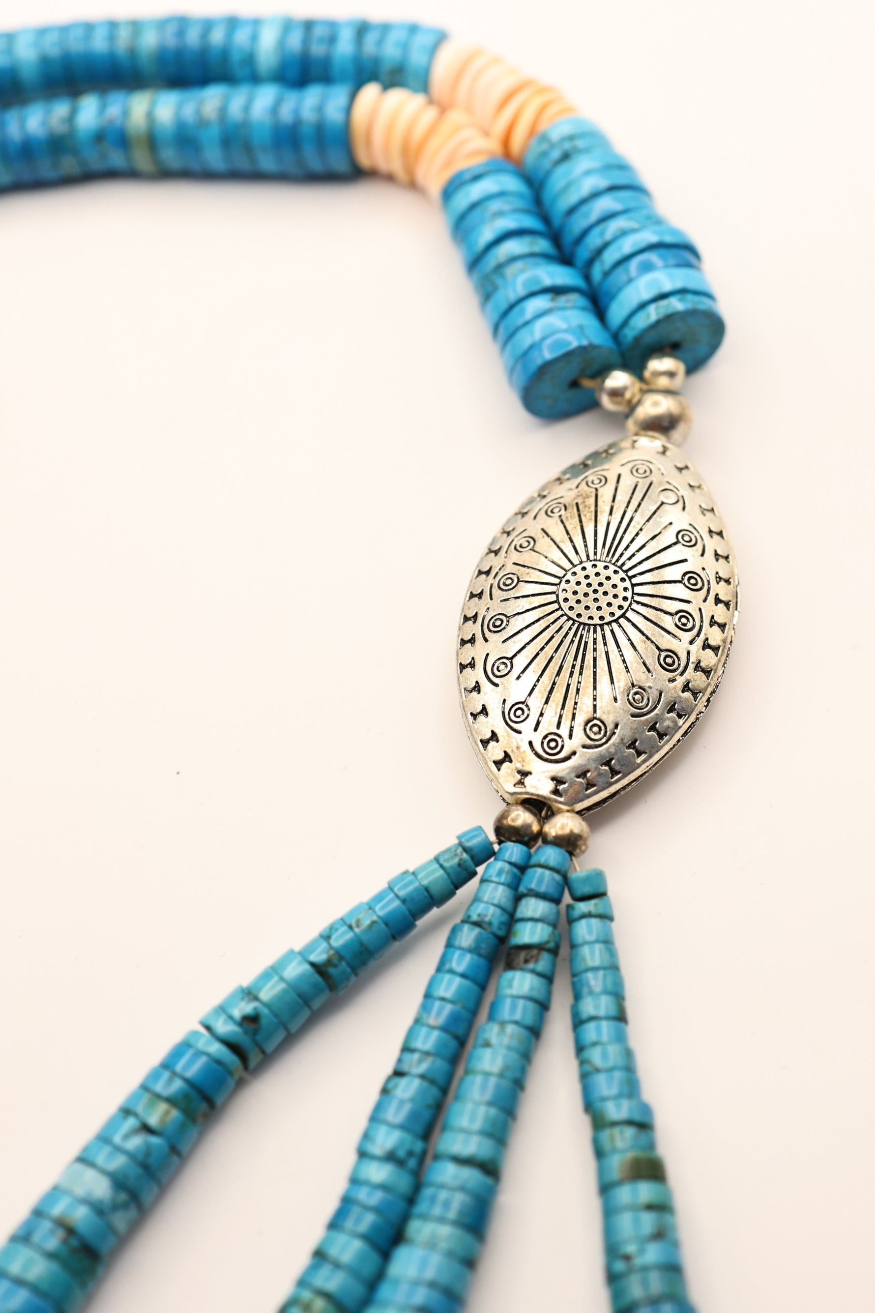 Royston Turquoise Necklace features handcut turquoise discs and and coral discs. Stunning piece of vintage navajo jewelry. Stones are arranged on a handwoven cord for a loop necklace design (no clasp). Also features a sterling silver shell pendant.