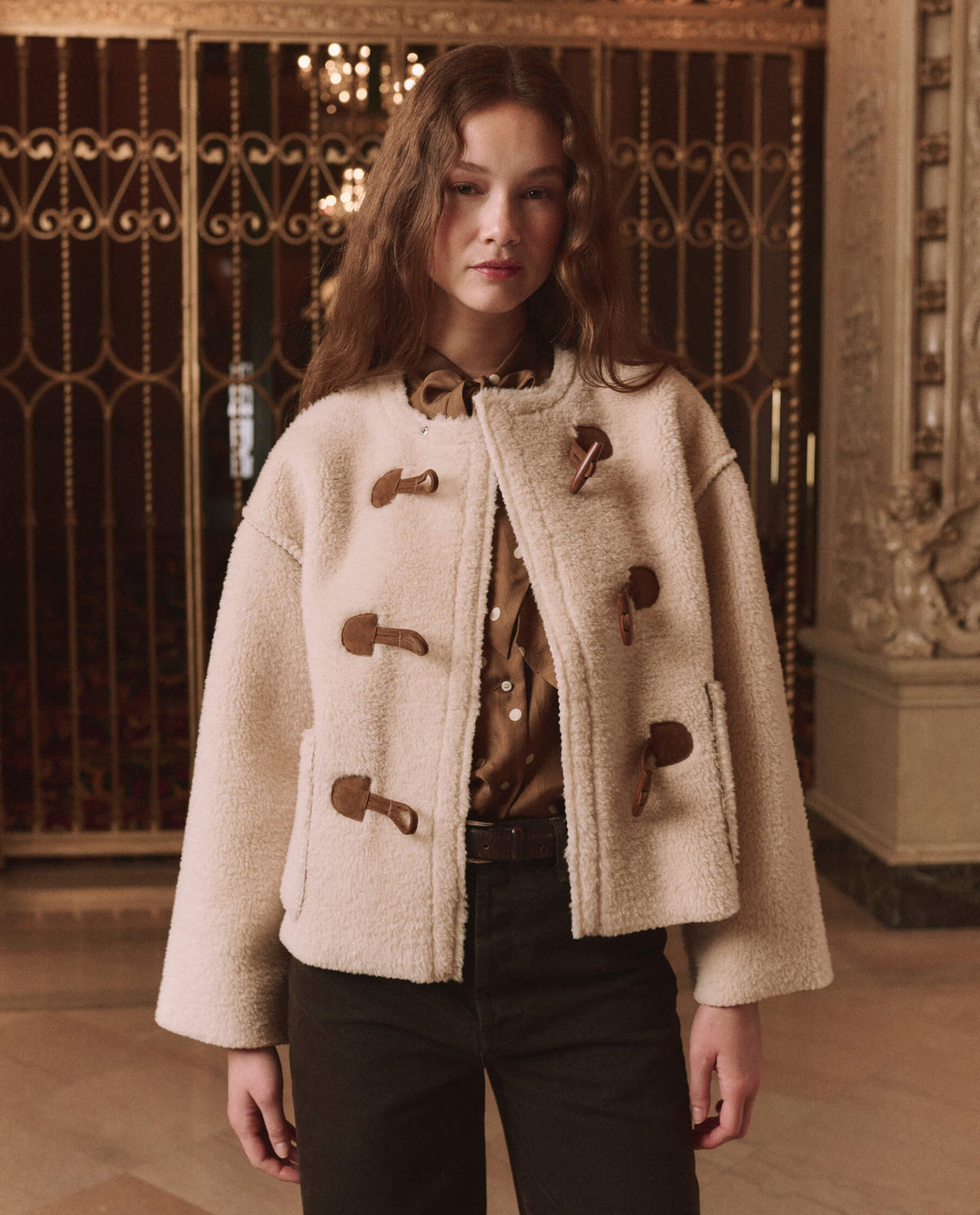 The Great Woodside Toggle Coat Cream layered over a silk blouse and brown denim cowgirl style