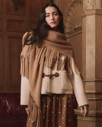 The Great Big Sweater Fringe Scarf Camel wrapped over a cream toggle coat for layered western fashion