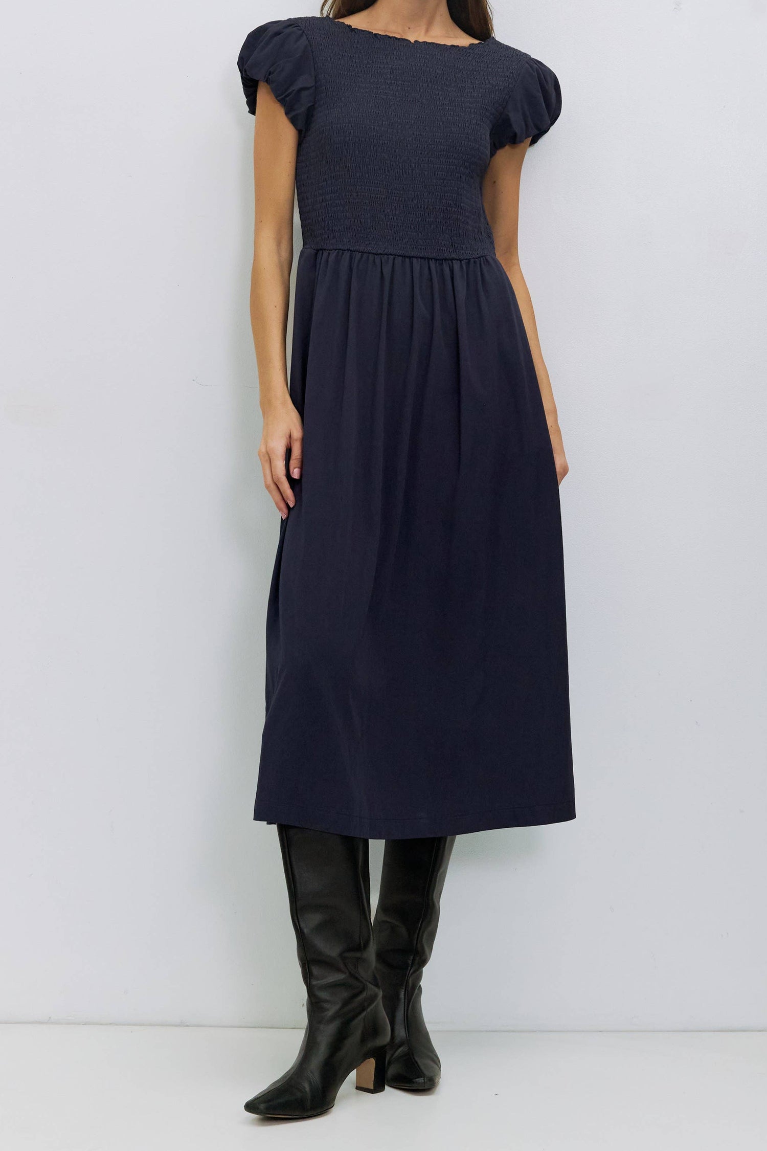 The Anastasia Dress pairs its lightweight feel with a smocked bodice that creates a close, flattering fit short puff sleeves and a crew neckline give it an airy, feminine touch, while the midi skirt includes discreet side slit pockets. Fully lined for comfort and structure. at boltranchstore.com