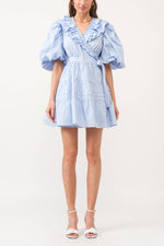 The Josefine Dress is a light blue mini dress crafted from cotton poplin, featuring a flattering V-neck collar, delicate ruffles, and charming puff sleeves. Womens at boltranchstore.com