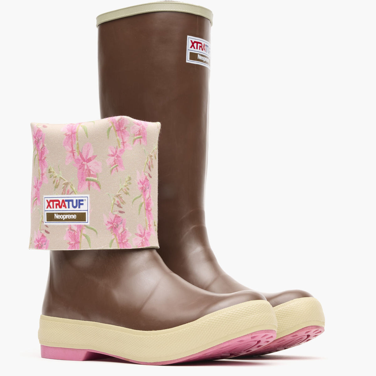 XWL4FWXTRATUF  Womens Fireweed 15 Legacy Boot At boltranchstore.com in stock free shipping A pair of brown rubber rain boots with beige soles and pink soles, featuring a matching beige and pink floral fleece boot cover. 