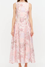 A woman modeling a sleeveless midi dress with a pink and white floral pattern, lace trim at the neckline and waist, and a flared skirt, set against a plain white studio background. Shop today at boltranchstore.com