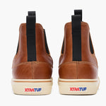 XTRATUF Mens Leather Chelsea Ankle Deck Boot Cashew front and rear pull on tabs with red and blue logo heel on a cream rubber sole cowboy